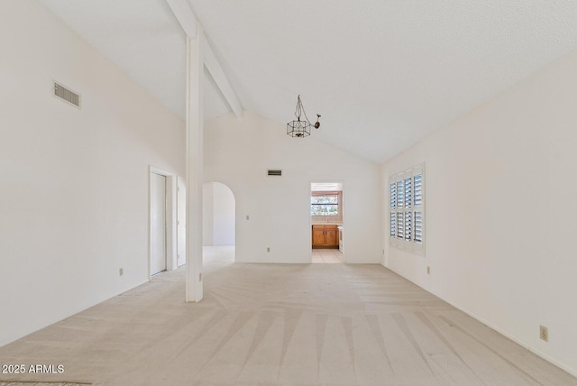 spare room featuring visible vents, arched walkways, light colored carpet, high vaulted ceiling, and beam ceiling