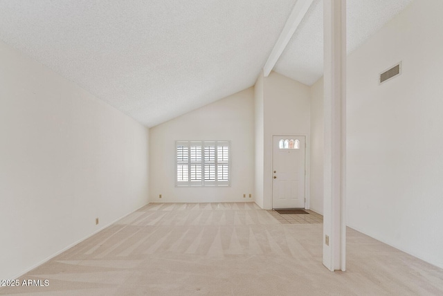 foyer with a textured ceiling, high vaulted ceiling, light colored carpet, visible vents, and beam ceiling