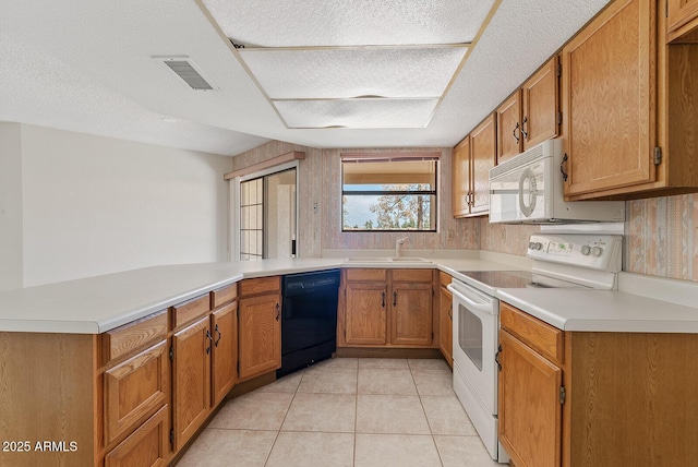 kitchen featuring light tile patterned flooring, a peninsula, white appliances, a sink, and light countertops