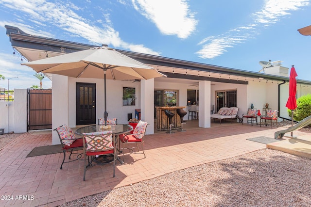 back of property featuring an outdoor bar and a patio area