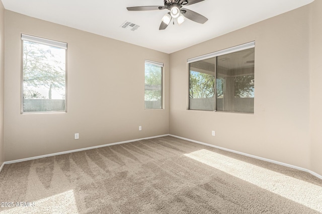 carpeted spare room featuring ceiling fan