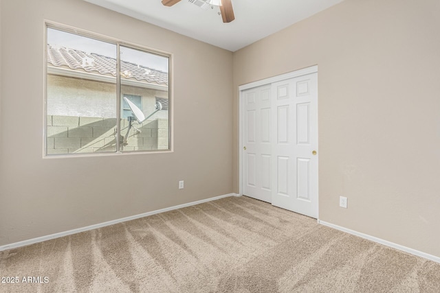 unfurnished bedroom with a closet, ceiling fan, and carpet flooring