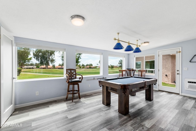 recreation room featuring healthy amount of natural light, wood finished floors, billiards table, and a wall mounted AC