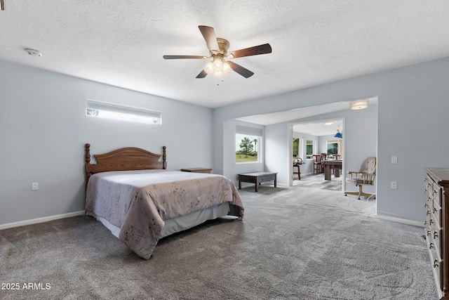 bedroom featuring carpet flooring, a textured ceiling, baseboards, and ceiling fan