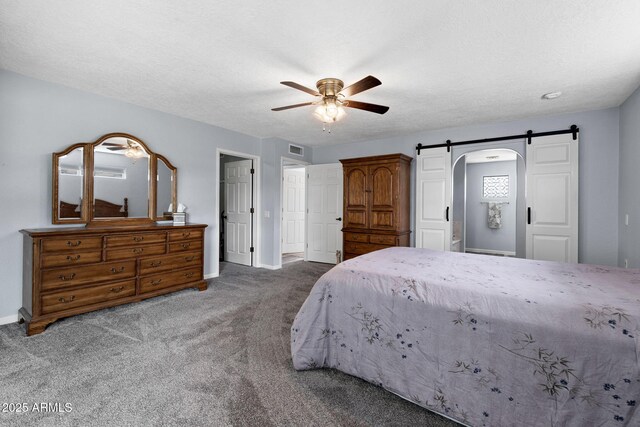carpeted bedroom with a barn door, baseboards, and a ceiling fan