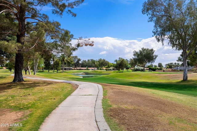 view of community with a yard, a water view, and golf course view