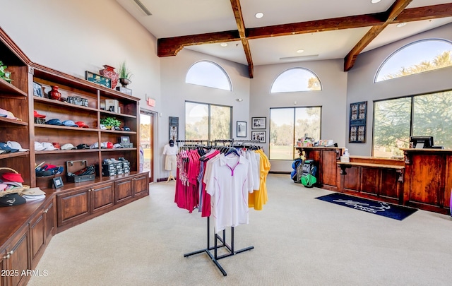 misc room featuring beam ceiling, plenty of natural light, light carpet, a high ceiling, and recessed lighting