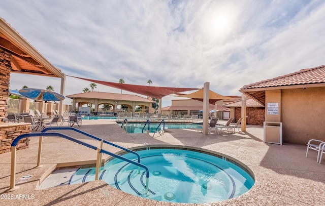 community pool with a community hot tub, a patio, and fence