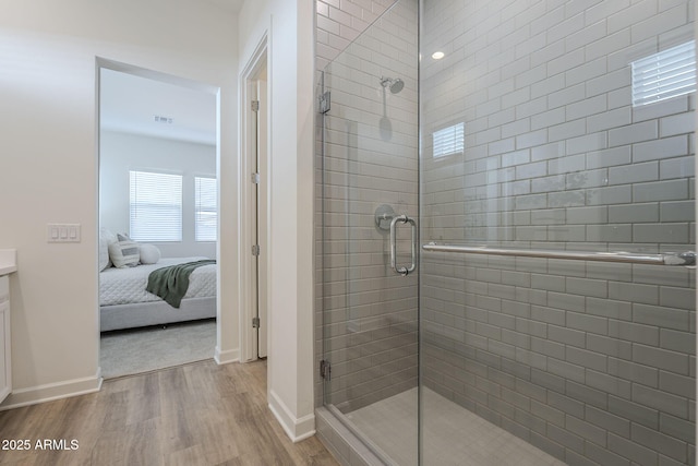 full bathroom with visible vents, connected bathroom, wood finished floors, vanity, and a shower stall