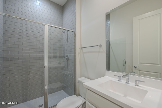 bathroom with toilet, a shower stall, and vanity