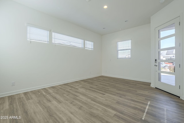 unfurnished room featuring recessed lighting, baseboards, and wood finished floors