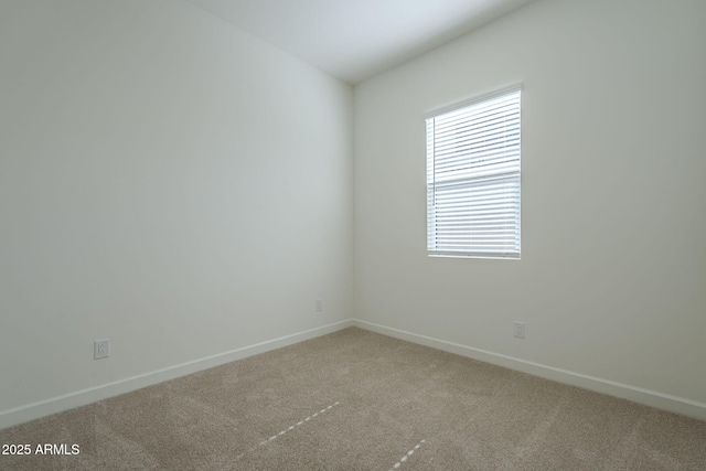 carpeted empty room featuring baseboards