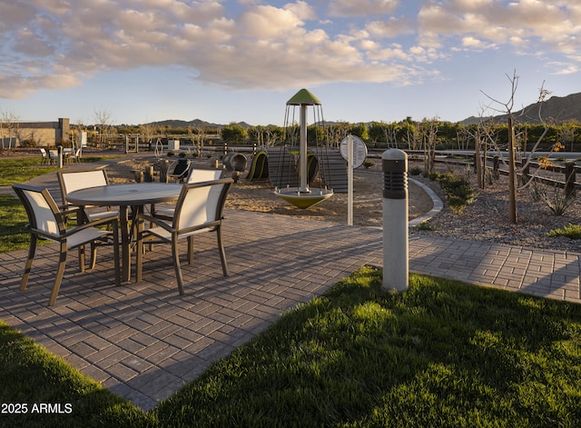 view of patio / terrace with playground community and a mountain view