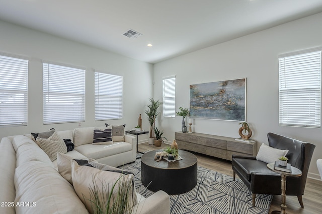 living room featuring recessed lighting, wood finished floors, visible vents, and baseboards