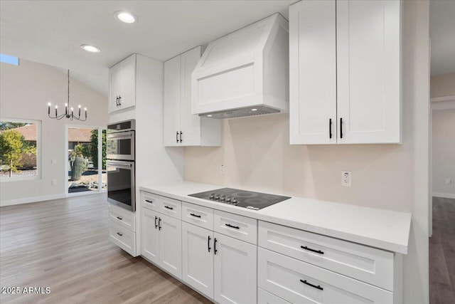 kitchen featuring black electric cooktop, custom range hood, and white cabinets