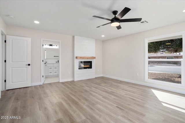 unfurnished living room with light hardwood / wood-style flooring, a fireplace, and ceiling fan