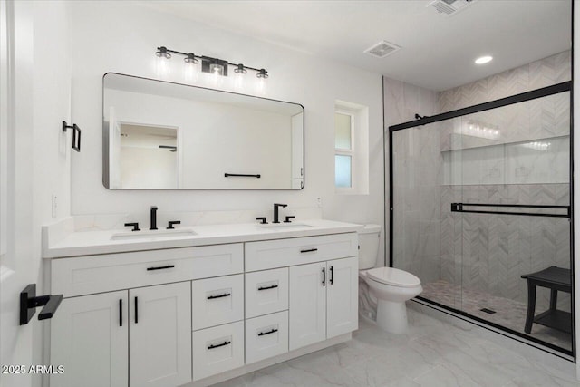 bathroom featuring vanity, toilet, and a shower with shower door