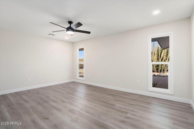 spare room with ceiling fan, a healthy amount of sunlight, and light wood-type flooring