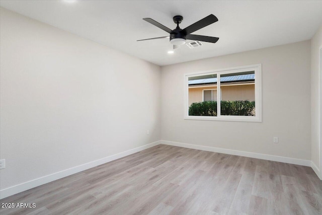 spare room with ceiling fan and light wood-type flooring