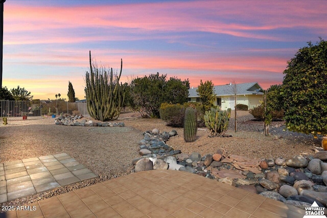 yard at dusk featuring a patio area