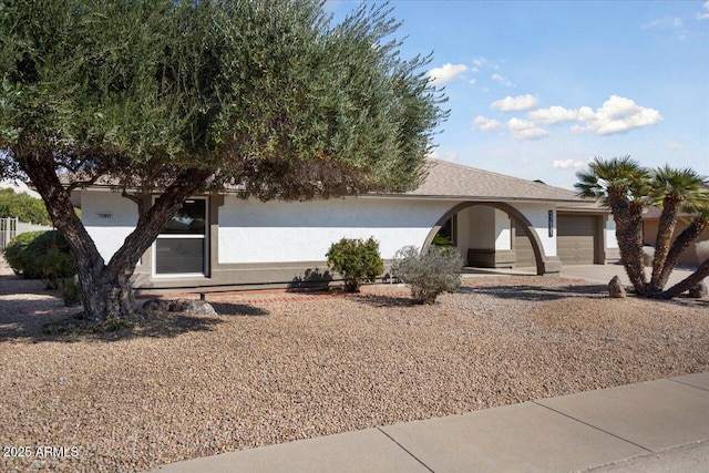 view of property hidden behind natural elements featuring a garage