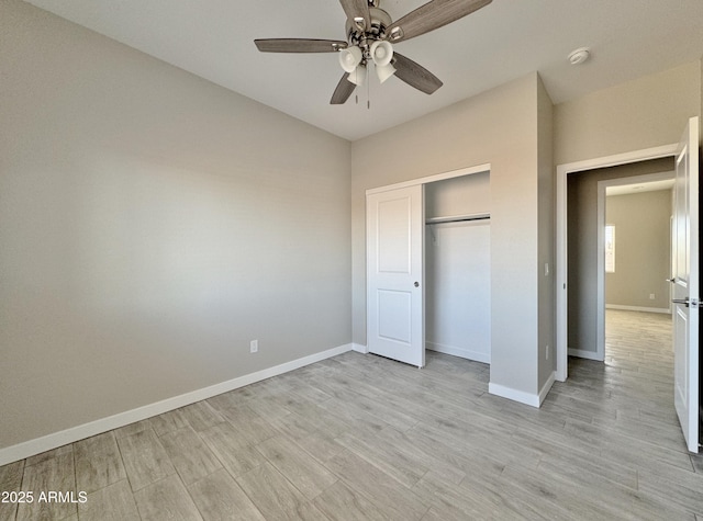 unfurnished bedroom with ceiling fan, light hardwood / wood-style floors, fridge, and a closet