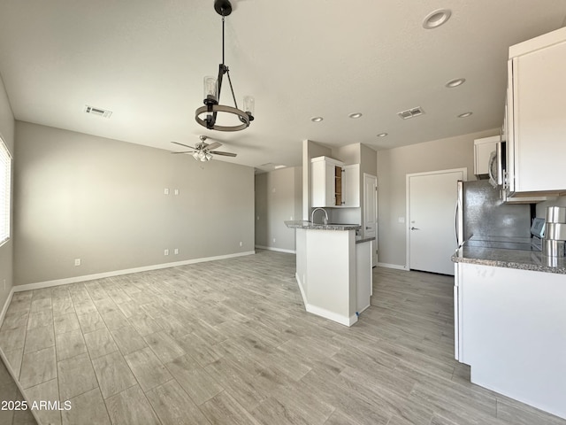 kitchen with white cabinetry, ceiling fan, hanging light fixtures, light hardwood / wood-style flooring, and kitchen peninsula