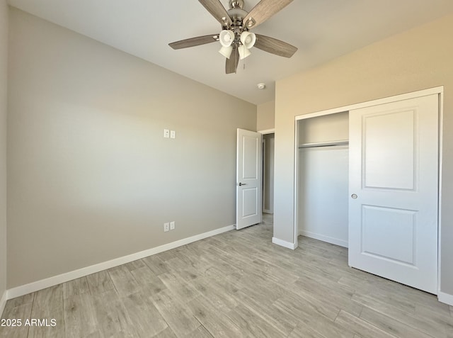 unfurnished bedroom featuring ceiling fan, light hardwood / wood-style floors, and a closet