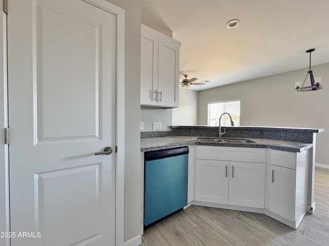 kitchen with kitchen peninsula, dishwashing machine, ceiling fan, sink, and white cabinetry