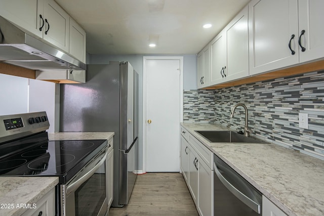 kitchen featuring light stone countertops, stainless steel appliances, white cabinets, and sink