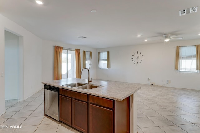 kitchen with dishwasher, sink, ceiling fan, light tile patterned floors, and an island with sink