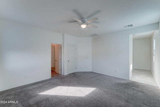 spare room featuring ceiling fan and light colored carpet