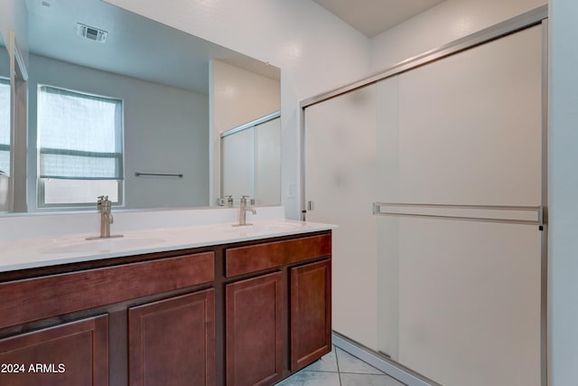 bathroom with tile patterned flooring, vanity, and a shower with door