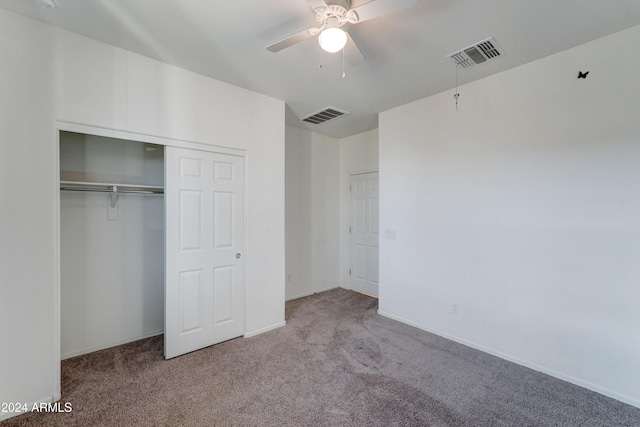 unfurnished bedroom with carpet, a closet, and ceiling fan