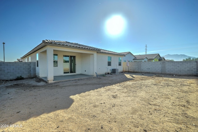 rear view of house featuring cooling unit and a patio area