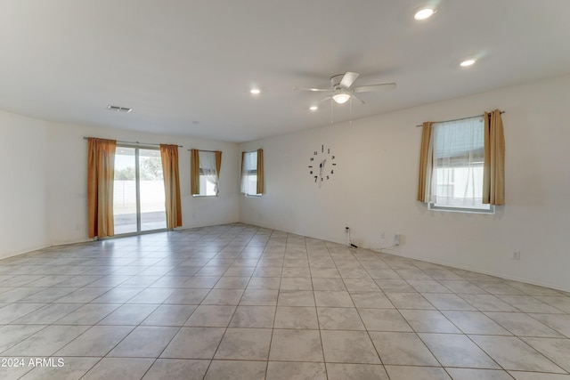 empty room with ceiling fan and light tile patterned floors