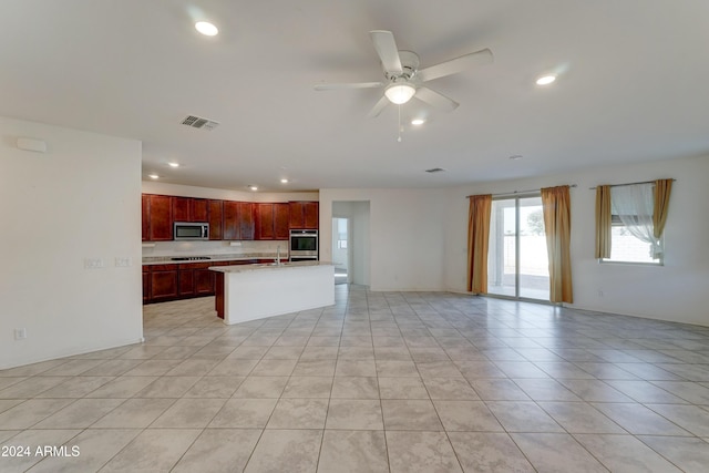 kitchen with a center island with sink, sink, ceiling fan, light tile patterned flooring, and stainless steel appliances