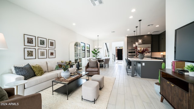 living room featuring an inviting chandelier and light hardwood / wood-style flooring