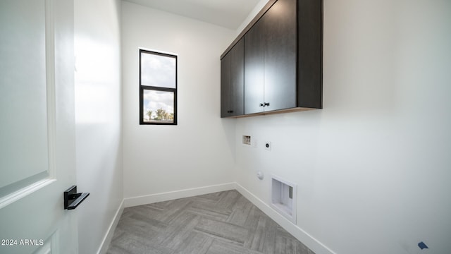 laundry room featuring hookup for a washing machine, light parquet flooring, hookup for an electric dryer, cabinets, and gas dryer hookup