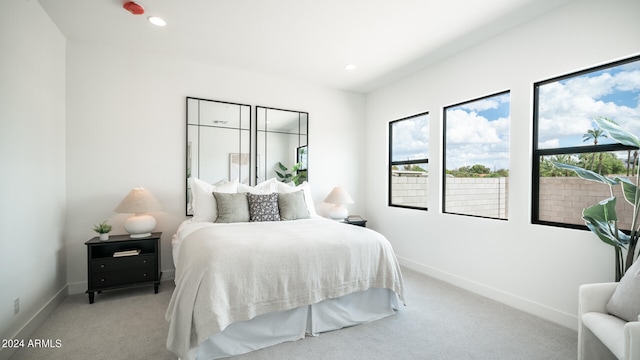 bedroom featuring multiple windows and light colored carpet