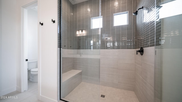 bathroom featuring toilet, tile patterned floors, and an enclosed shower