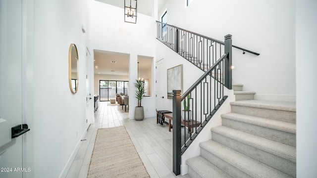 stairs featuring hardwood / wood-style flooring and a high ceiling