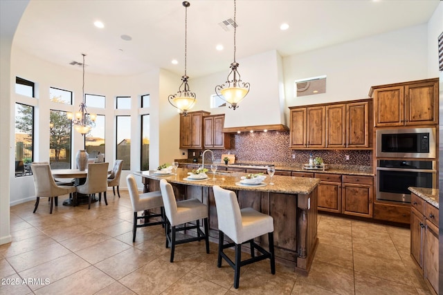 kitchen featuring visible vents, brown cabinets, and appliances with stainless steel finishes