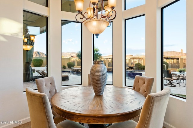 dining room with baseboards and a chandelier