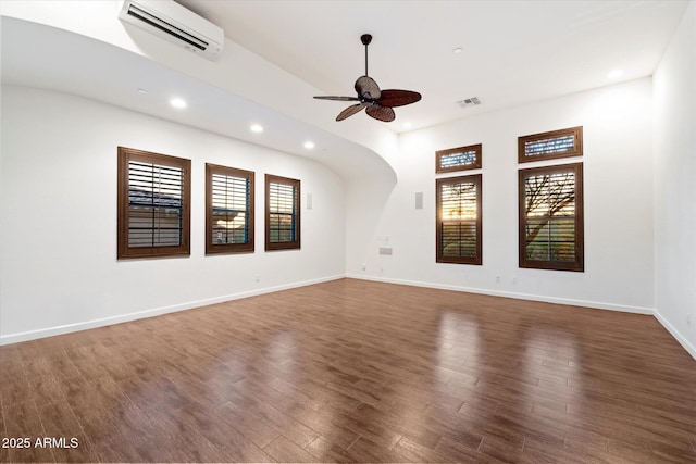 spare room with visible vents, a healthy amount of sunlight, a ceiling fan, and a wall mounted AC