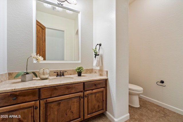 bathroom with vanity, tile patterned floors, toilet, and baseboards