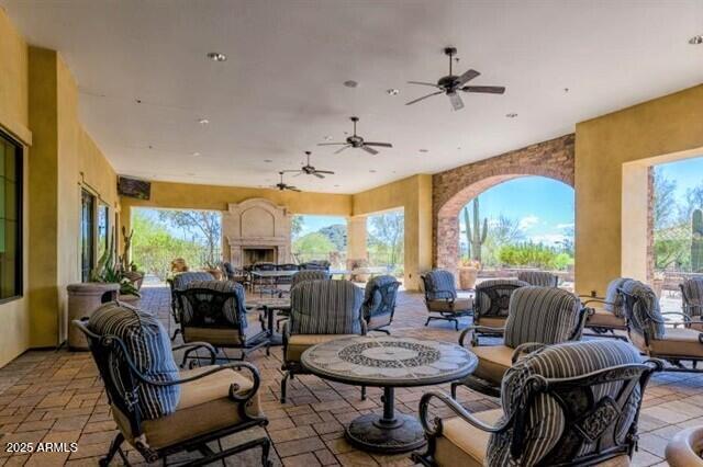 view of patio / terrace featuring an outdoor living space with a fireplace and a ceiling fan