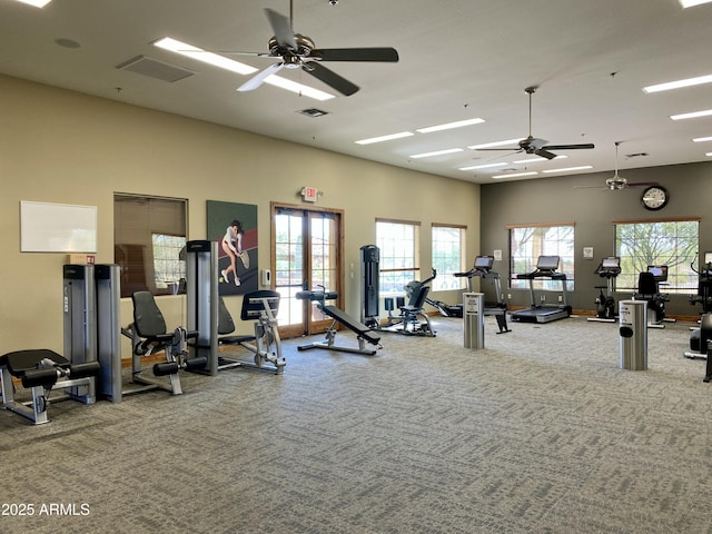 workout area featuring carpet, a high ceiling, a ceiling fan, and a healthy amount of sunlight