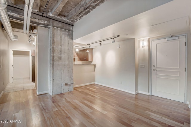 unfurnished living room with light hardwood / wood-style floors and rail lighting