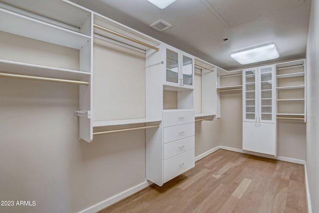 walk in closet with light wood-type flooring